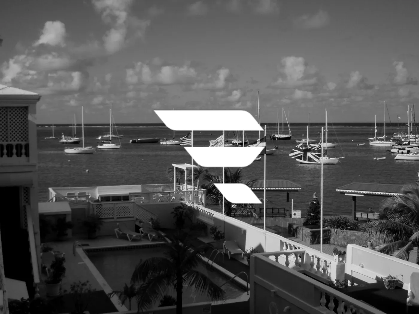 Sailboats moored in a harbour seen from a waterfront terrace