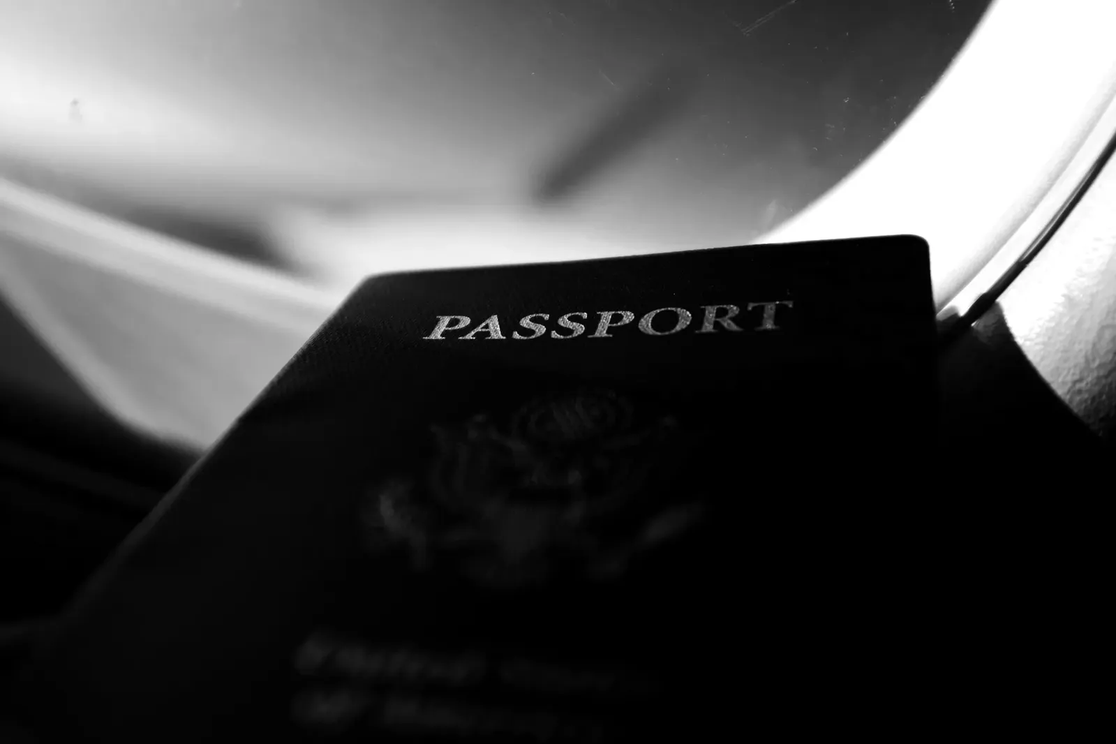 Un pasaporte junto a la ventanilla de un avión