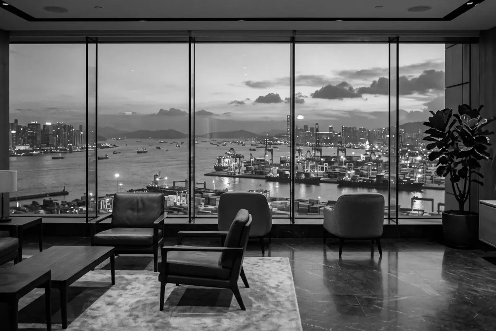 Un salón con ventanales sobre un puerto al atardecer